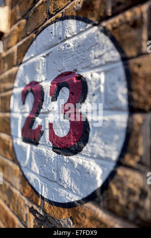 Number 23 painted on a brick wall in London Stock Photo