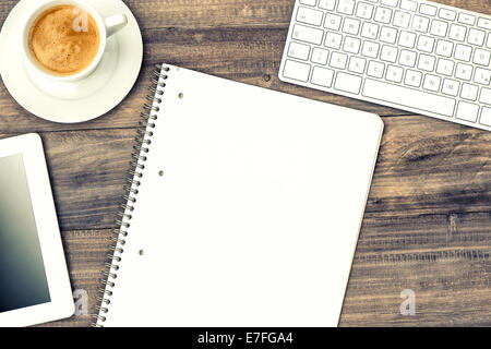 digital tablet pc, keyboard and cup of coffee on wooden table. retro style toned picture Stock Photo