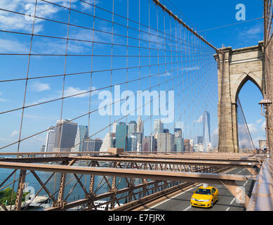 The New York City Skyline from Brooklyn Bridge with a typical Yellow Taxi on the bridge Stock Photo
