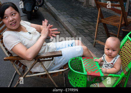 Mother take car of his children in the streets of Shanghai. Bringing children to live in Shanghai can create lots of anxieties. Stock Photo