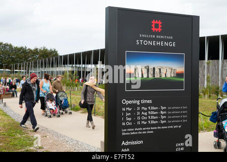 Tourist visitors pass the opening time & information sign at the entrance of the new Visitor centre Stonehenge / Stone Henge UK. (70) Stock Photo