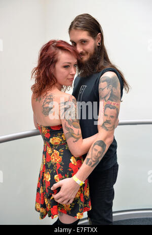 Garden City, New York, USA. 14th September 2014. PAT SULLY and CATERINA, of Massapequa, are at the United Ink Flight 914 tattoo convention at the Cradle of Aviation museum of Long Island. Later that night, Caterina was suspended from two ropes with hooks pierced through the skin of her back, at the outdoor body suspension show. Credit:  Ann E Parry/Alamy Live News Stock Photo