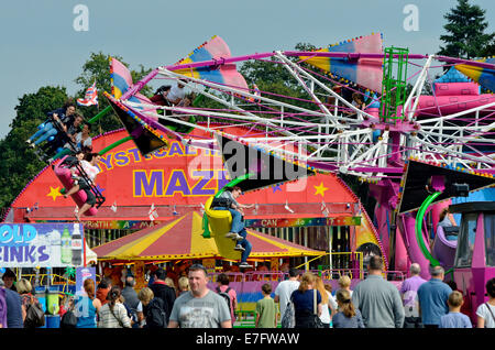 All the fun of the fair -  stands at a traditional funfair with families enjoying the atmosphere and rides.air. Stock Photo