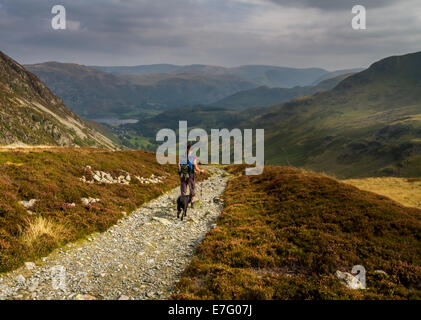 Hiker admiring the beautiful view towards Ullswater from the top of the Glenridding valley, Lake District, Uk Stock Photo