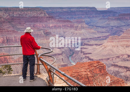 Senior man looking out over Hopi Point, Grand Canyon, Arizona. Focus on foreground. Stock Photo