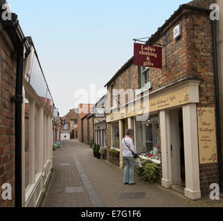 Narrow almost deserted pedestrian mall with woman window shopping  in English town of Pickering Stock Photo