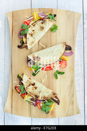 Tacos filled with roasted portobello mushrooms, zucchini, purple onions, with cherry tomatoes, cilantro and cheese Stock Photo