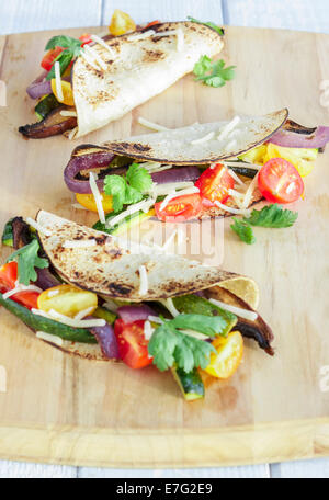 Tacos filled with roasted portobello mushrooms, zucchini, purple onions, with cherry tomatoes, cilantro and cheese Stock Photo
