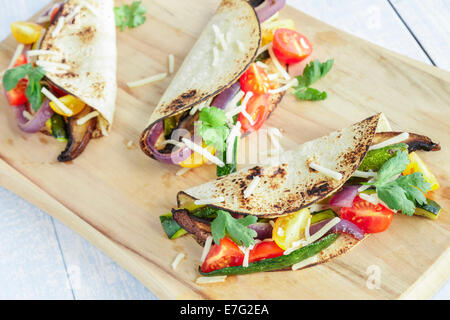 Tacos filled with roasted portobello mushrooms, zucchini, purple onions, with cherry tomatoes, cilantro and cheese Stock Photo