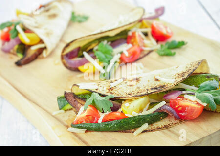 Tacos filled with roasted portobello mushrooms, zucchini, purple onions, with cherry tomatoes, cilantro and cheese Stock Photo