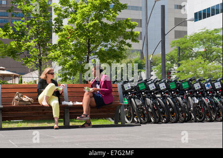 Office workers having lunch outdoors on Victoria Square,  Montreal, province of Quebec, Canada. Stock Photo