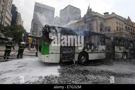 Sao Paulo, Brazil. 16th Sep, 2014. Firefighters outfire a bus during the clash between the Military Police and the residents of the disused hotel in Sao Paulo, Brazil, Sept. 16, 2014. The eviction of homeless squatters from a disused hotel in the largest Brazilian city of Sao Paulo Tuesday led to violence and to 80 arrests, local authorities said. Credit:  Agencia Estado/Xinhua/Alamy Live News Stock Photo