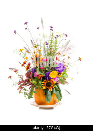 Wild flowers bouquet in carved pumpkin vase over white background Stock Photo