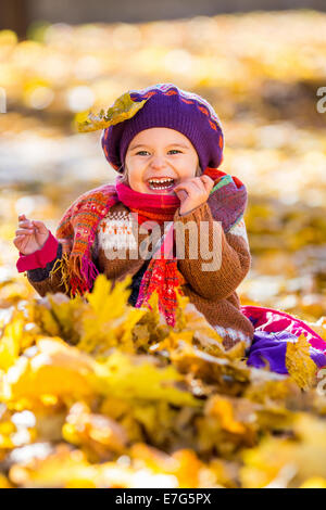 Happy little girl playing in the autumn park Stock Photo