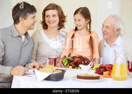 Big family looking at young man during traditional Thanksgiving dinner Stock Photo