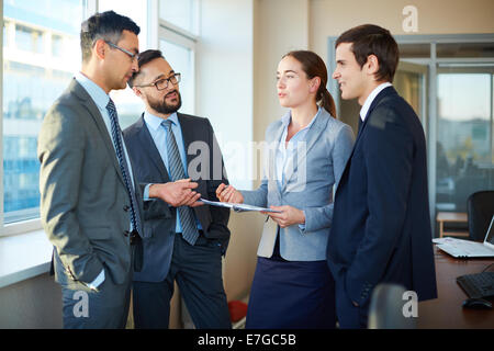 Group of colleagues discussing documents and business plans in office Stock Photo