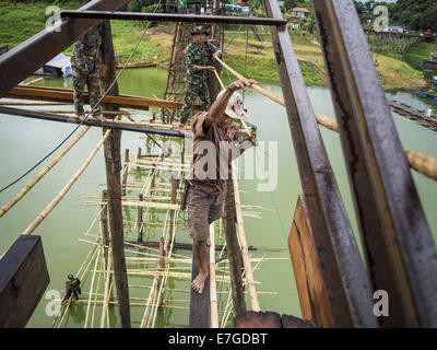 Sangkhla Buri, Kanchanaburi, Thailand. 17th Sep, 2014. Thai soldiers and members of the Mon community work on the repair of the Mon Bridge. The 2800 foot long (850 meters) Saphan Mon (Mon Bridge) spans the Song Kalia River. It is reportedly second longest wooden bridge in the world. The bridge was severely damaged during heavy rainfall in July 2013 when its 230 foot middle section (70 meters) collapsed during flooding. © ZUMA Press, Inc./Alamy Live News Stock Photo
