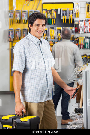 Tool Purchasing Portrait of adult male in hardware store buying bolts for repair Stock ...