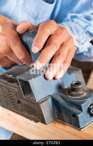 Carpenter's Hands Shaving Wood With Electric Planer Stock Photo