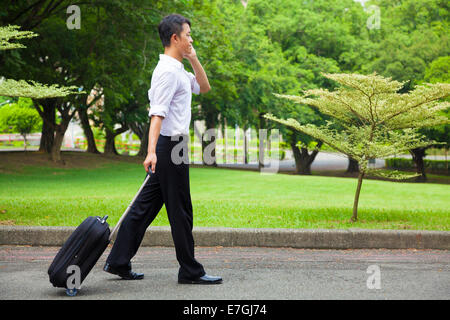 businessman walking and using a phone on the road Stock Photo