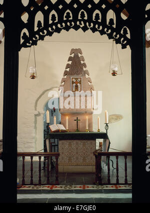Restored C12th Romanesque shrine in chancel of St Melangell's church, Powys, seen through C15th oak chancel screen with apse doorway to rear. Stock Photo