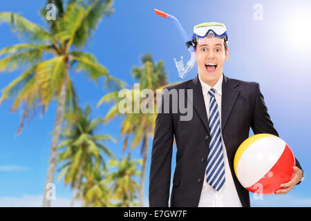 Man standing on beach with snorkel and beach ball Stock Photo
