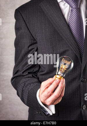 Fraud concept in a filament lightbulb. Stock Photo