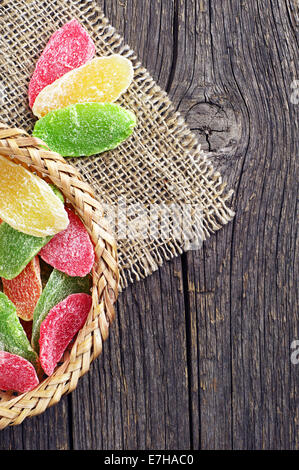 Dried pineapple slices in wicker bowl and near on vintage wooden table Stock Photo