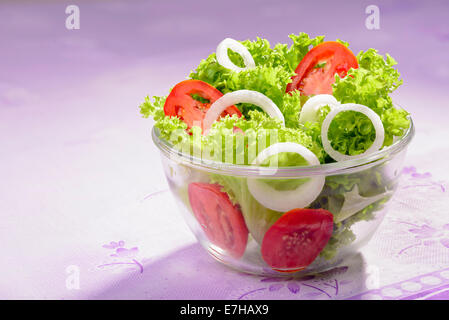 Mixed fresh salad with curly coral lettuce, white onions and red tomatoes Stock Photo