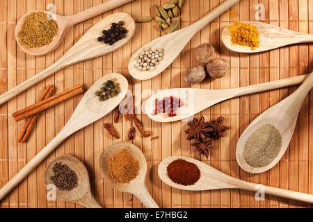 Variety of spices on wooden cooking spoons, high angle view Stock Photo