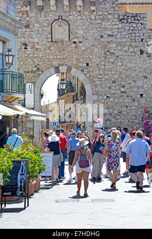 Tour guides holding up marker boards (flag) before entering the old town gate at Corso Umberto Taormina Province of Messina Sicily Italy Stock Photo