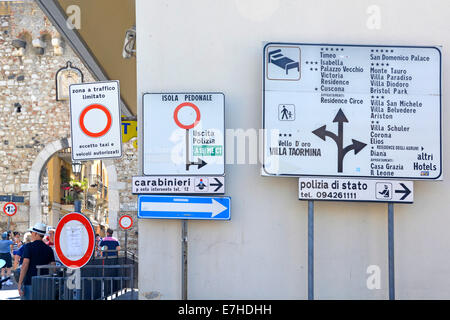 Italian road signs at start of the pedestrianised shopping street Corso Umberto with arched old town gate at Corso Umberto Taormina Sicily Italy Stock Photo