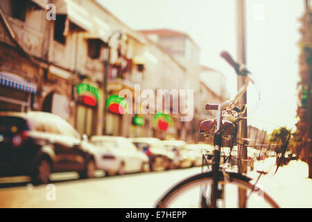 Blurred image of city street with bicycle at sunset with vintage instagram filter effect Stock Photo