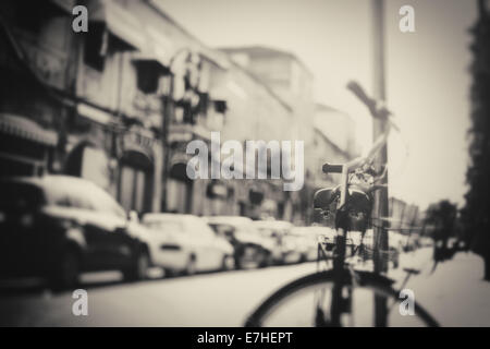 Blurred image of city street with bicycle at sunset with vintage black and white effect Stock Photo