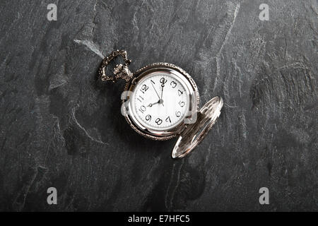 Pocket gray clock on dark gray slate texture Stock Photo