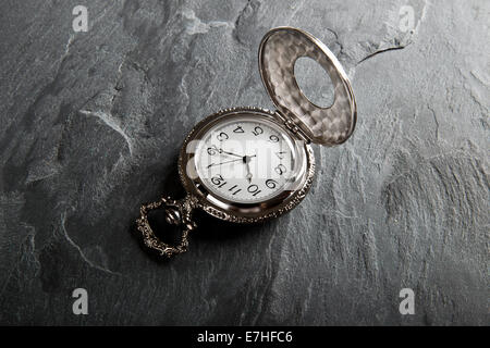 Pocket gray clock on dark gray slate texture Stock Photo
