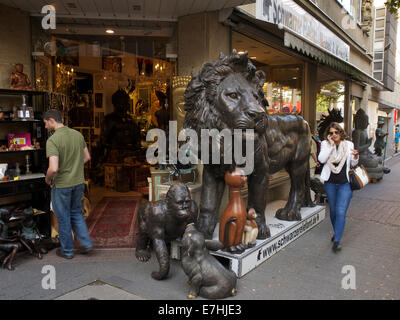 Shop in the city center of Cologne with huge bronze lion and people, Cologne, NRW, Germany Stock Photo