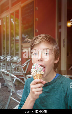 lucky teenager boy is eating his ice cream. Stock Photo