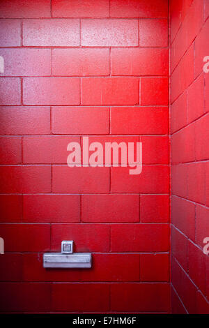 a very red painted brick wall with socket for backgrounds. Stock Photo