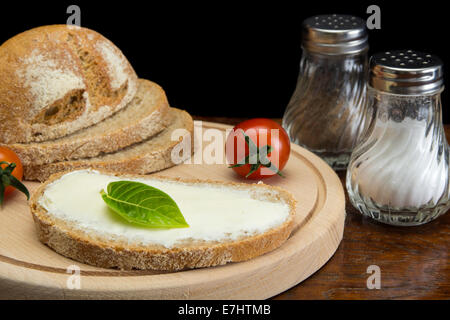 Close up image of spreading cream cheese on pumpernickel bread Stock Photo