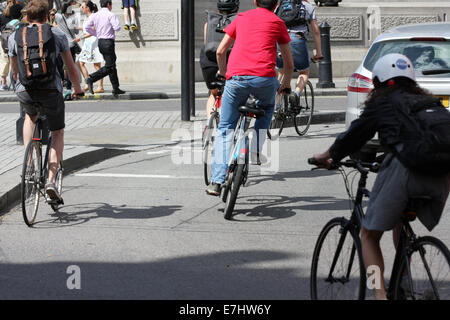 Rear view of cyclists and a car traveling around a roundabout in Trafalgar Square, London Stock Photo