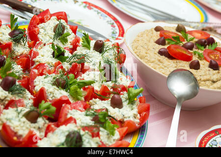 Stuffed tomatoes with cheese and eggplant salad on table Stock Photo