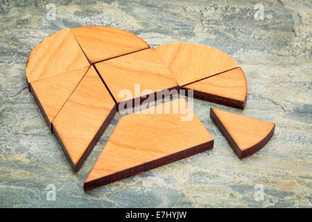 heart version of tangram, a traditional Chinese Puzzle Game made of different wood parts to build abstract figures from them, on Stock Photo