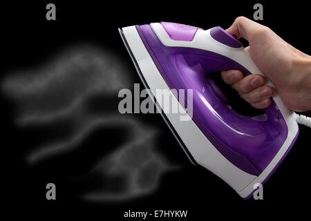 Electric iron with steam isolated on black background Stock Photo