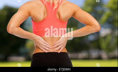 close up of sporty woman touching her back Stock Photo