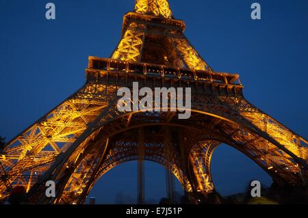 Eiffel Tower lit up in golden color by night against a deep blue sky Stock Photo