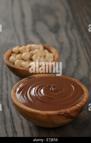 chocolate hazelnut cream in wood bowl, on old oak table Stock Photo