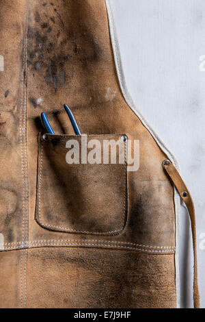 Leather workshop apron with pliers in the pocket. Stock Photo