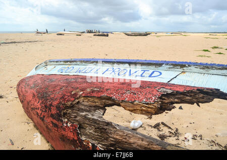 Wooden fishing boat wrecked on the beach of Robertsport, Liberia, reading 'God Will Provid' Stock Photo
