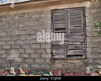 An abandoned building with barricaded windows in the village of Skala in Kefalonia Greece Stock Photo